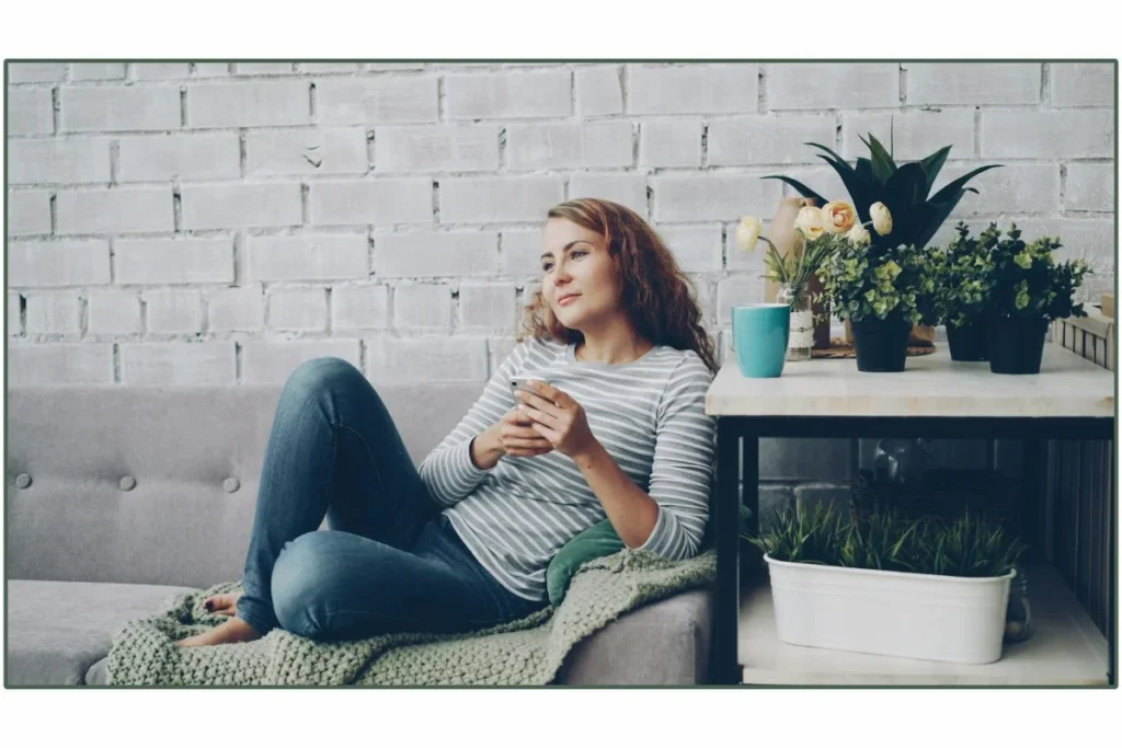 donna seduta a casa che riflette su un percorso nutrizionale